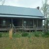 Dogtrot house with green roof and covered porch