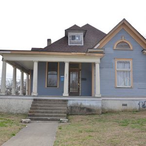 Blue house with gabled roof and covered porch on street corner