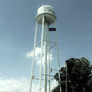 Three bay garage building and water tower with outbuildings