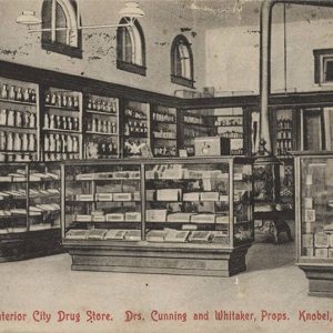 Interior of store with glass display cases and iron stove