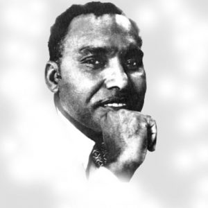 African-American man in white shirt and tie holding his fist to his chin