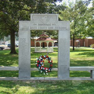 Engraved stone memorial gateway with wreath under it