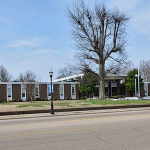 Single-story building with covered entrance and steps on street