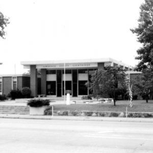 Single-story brick building with tall narrow windows and grounds