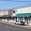 Brick storefronts with parked car on street and power lines