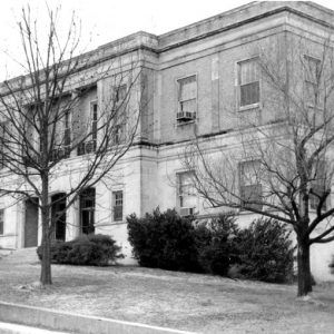 Two-story stone building with arched entrances and courtyard