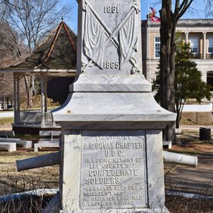 Crossed flags and engraved pedestal on stone monument in park