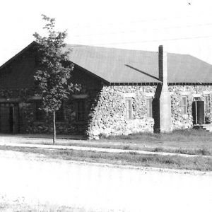 single story building with chimney and tree