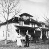 white man and woman standing outside multistory house with covered porch