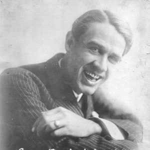 White man smiling in striped suit