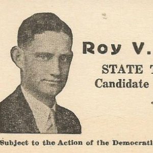 White man in suit and tie with text on card