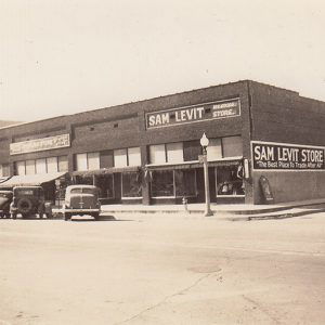 Brick storefronts on street with parked cars