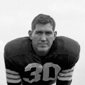 Young white man in football uniform bending forward