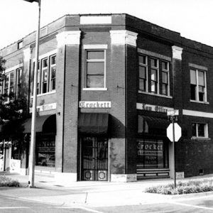 Brick building on street corner with "Crockett Law Office" signs and logo on windows