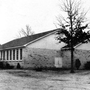 Single-story brick building with a wall containing twelve windows