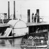 Side wheel paddle steamboat moored alongside ironclad