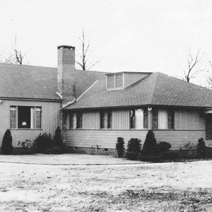 Lodge building with brick chimney with glass rear wall divided into windows