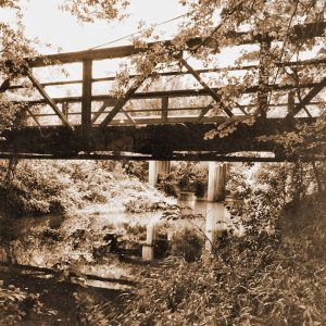 Side view of steel truss bridge with water underneath