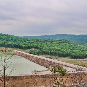 Lake dam with tree covered countryside in the background