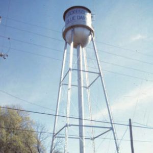 Water tower and brick building inside fence