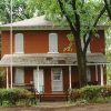 Two-story brick building with tree and sign "Logan County Museum"