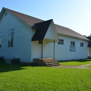 Single-story building with white siding and covered entrances