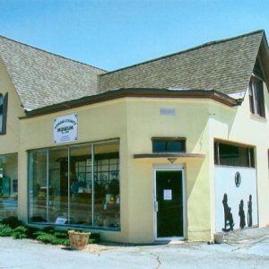 pale yellow building with hip and valley roof and corner door