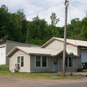 Single-story house with two car garage on street corner with three car garage and houses behind it