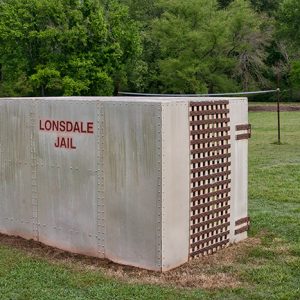 Concrete box with cage door and "Lonsdale Jail" in red written on the side