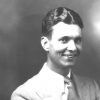 White man smiling in suit and tie