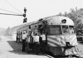 White men wearing white shirts and hats loading a train car