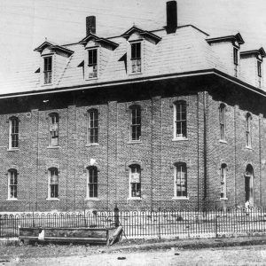 Three-story brick building and iron fence