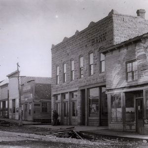 Two story brick bank building amid row of other storefronts on downtown square