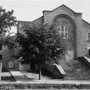 Stone multistory church building with trees around it