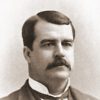 White man with mustache in suit and tie