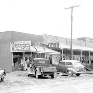 Brick storefronts on street with parked cars