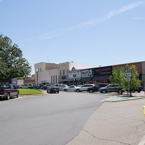 Parked cars outside storefront buildings in town