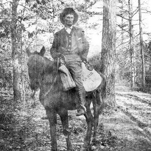 White men sitting on horse in wooded area