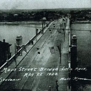 View overlooking concrete river bridge with flags hanging above it