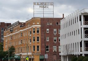 Multistory brick building "Majestic Hotel" and street with signs