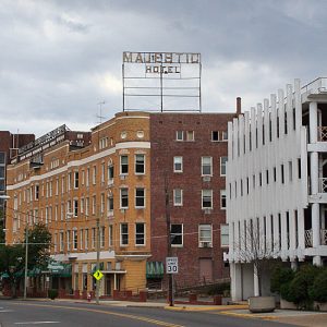 Multistory brick building "Majestic Hotel" and street with signs