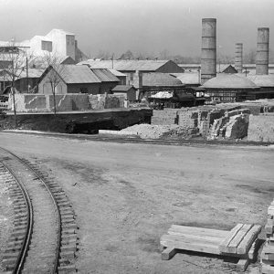 Industrial buildings with smoke stacks bricks and train tracks