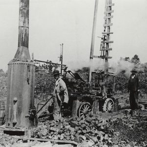 White men with machinery in rock quarry