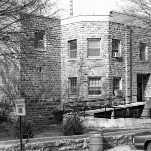 Two-story stone building with parking lot and accessibility ramp