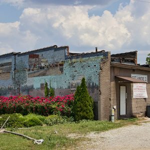 Mural depicting town and rural scenes on side of brick building