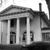 Multistory house with four columns and screened-in side porch