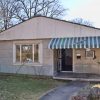 one-story house with green and white metal awning over porch