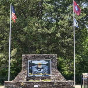 Stone monument with sign between two flagpoles