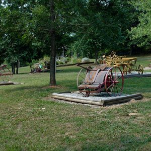 Farming machinery on display in a field with wooden platforms