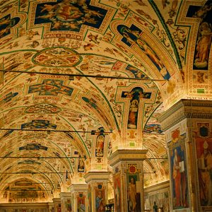 High arched ceiling and columns with religious iconography painted on them inside multistory church library